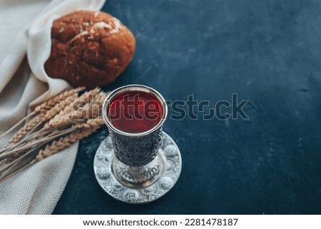 Bread, wine and ears of wheat on a dark background, communion concept.
