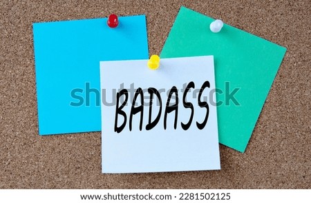 BADASS - word on colorful pieces of paper attached to the note board. Info concept