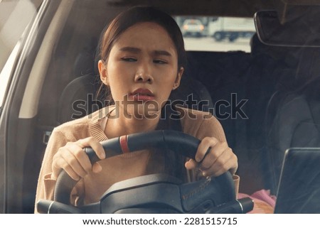 Portrait female driver unhappy with vehicle travel : Asian woman sitting bored inside the car while driving on the road during the morning rush hour in traffic jams wastes her time traveling.
 Royalty-Free Stock Photo #2281515715