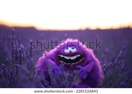 Fluffy toy Art from Monsters Inc cartoon sits in a lavender field Royalty-Free Stock Photo #2281526843