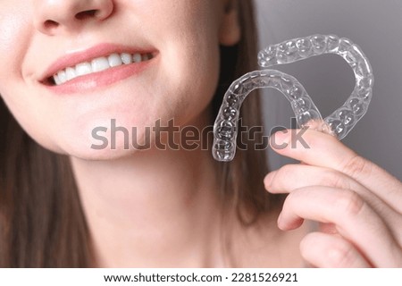 Aligners for straightening teeth in a woman's hand Royalty-Free Stock Photo #2281526921