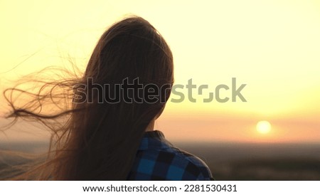 young girl looks sunset sky. free girl with hair disheveled in the wind. romantic girl outdoors in sunlight. woman dream. Girl dream pray hair sunset dawn. sky sun youth ask help wind silhouette. Royalty-Free Stock Photo #2281530431