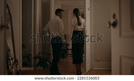 Gentle man inviting woman at romantic evening room. Interested lady watching candles table interior. Loving couple celebrating anniversary at cozy home. Married sweethearts walking to dining place Royalty-Free Stock Photo #2281536003
