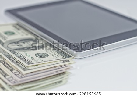 Tablet-PC and dollars on white background