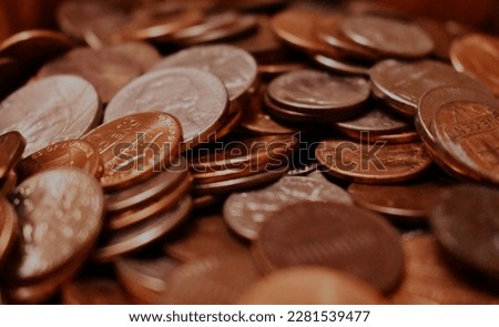 A pile of round penny coins stacked on top of each other, brown in color and with a shiny metallic texture, showing the heads and tails of the coins