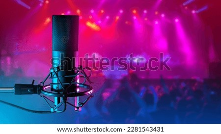 Acoustic microphone. Microphone for club musicians. Concert hall blurred. Condenser microphone on tripod. Concept of selling sound recording equipment. Audio technologies. Micro for rock concert