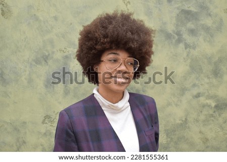 Portrait of a young woman model of African descent with glasses smiles as she looks at the camera Royalty-Free Stock Photo #2281555361