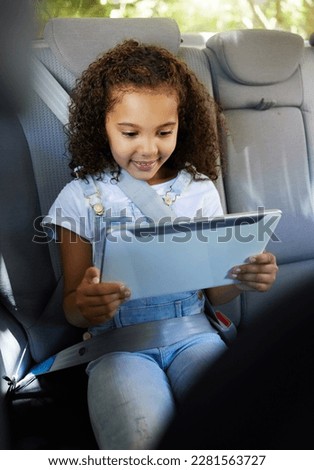 Happy, watching and a child in a car with a tablet for a movie, cartoons or video. Smile, travel and a girl sitting in a vehicle with tech, streaming online and enjoying a film for entertainment