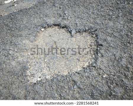 asphalt that is damaged or has holes in the shape of love