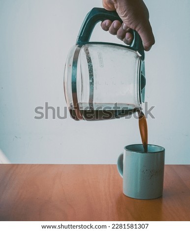 Close up of men pouring milk into a coffee cup and ready to enjoy it. Coffee, cappuccino made at home.