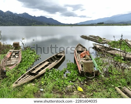 The view of the Selorejo dam with fishing boats looks beautiful surrounded by green hills and above the water there are water hyacinth plants in Ngantang Malang ,Selorejo