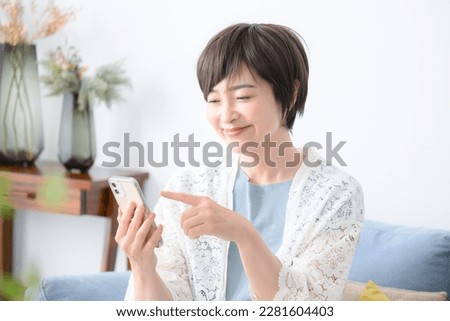 Smiling woman looking at her phone and tapping