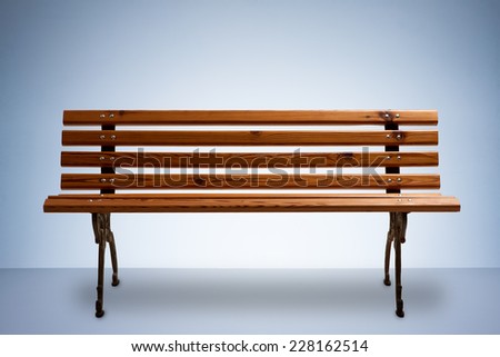 Wooden Park Bench Isolated on Blue Studio Background with Text Space
