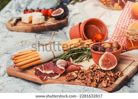 Close up delicious picnic food on blanket concept photo. Romantic summer outing. Front view photography with blurred background. High quality picture for wallpaper, travel blog, magazine, article
