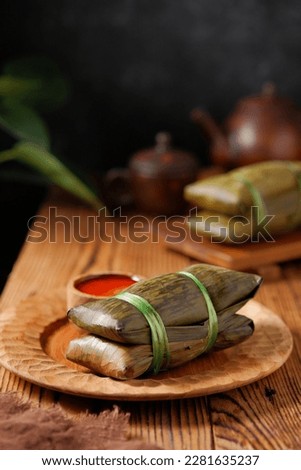 Buras is traditional food or snack from Indonesia. It's made of rice, salt, and coconut milk served with peanut sauce.  Royalty-Free Stock Photo #2281635237