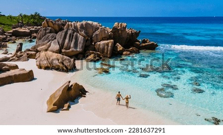 Anse Cocos La Digue Seychelles, a young couple of men and women on a tropical beach during a luxury vacation in Seychelles. Tropical beach Anse Cocos La Digue Seychelles. Royalty-Free Stock Photo #2281637291