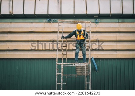 Construction worker wearing safety harnesses on Scaffolding at construction site. working at heights above ground ,Safe working for Scaffolding concept Royalty-Free Stock Photo #2281642293