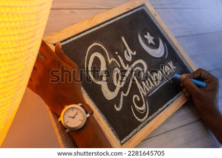 Eid Mubarak Calligraphy drawing, Artist drawing Edi Calligraphy on black board