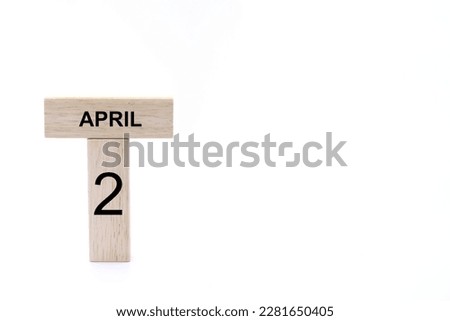 April 2 displayed wooden letter blocks on white background with space for print. Concept for calendar, reminder, date. 