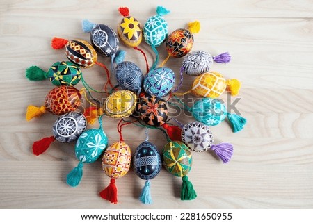 many colorful Ukrainian Easter eggs with tassels on a wooden background Royalty-Free Stock Photo #2281650955