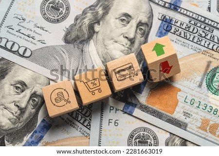 Inflation increase concept with icons showing inflation and price increases in wooden cubes on stack of dollars