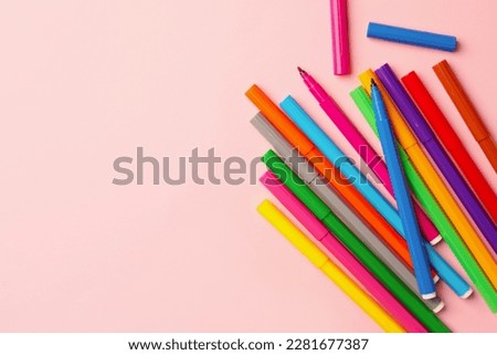 Many bright markers on pink background, flat lay. Space for text Royalty-Free Stock Photo #2281677387