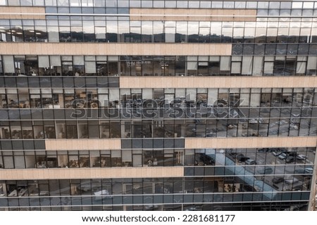 Drone photography of skyscraper windows up close during cloudy spring day. High angle view