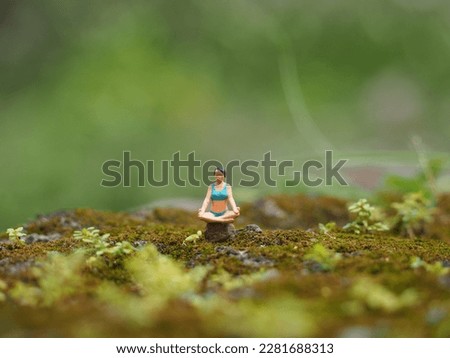 Healhty life concept design. Toy photography concept. Unfocus green grass and mini toy. Background is blurred.