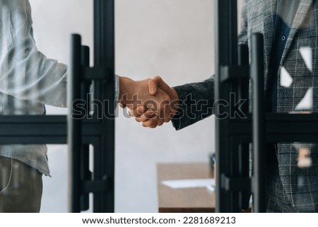 Close-up cropped shot of unrecognizable business partners shaking hands agree to deal or say hello at office. Two businessmen handshaking after successful project. Success, dealing, greeting concept. Royalty-Free Stock Photo #2281689213