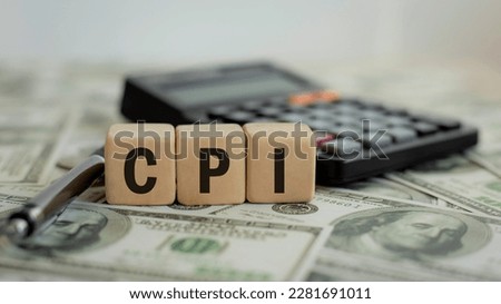 Word CPI on a wooden block. Consumer Price Index concept on dollar bills. Calculator Pen Business and CPI Royalty-Free Stock Photo #2281691011