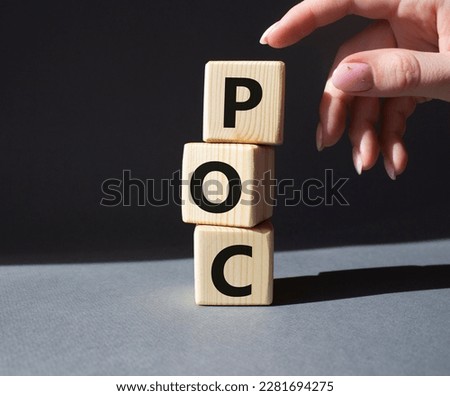 POC - Proof of Concept symbol. Wooden cubes with words POC. Businessman hand. Beautiful grey background. Business and POC concept. Copy space.