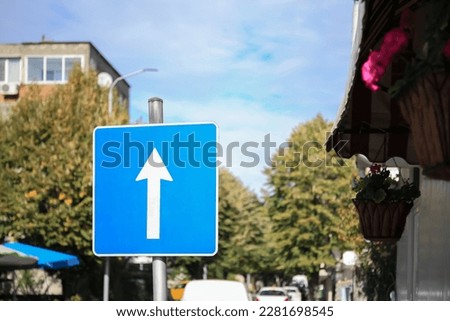 One Way Traffic sign near road with cars outdoors Royalty-Free Stock Photo #2281698545