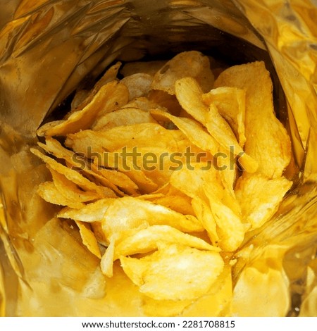 inside is an open pack of potato chips.  fatty junk food snack point.  package Royalty-Free Stock Photo #2281708815