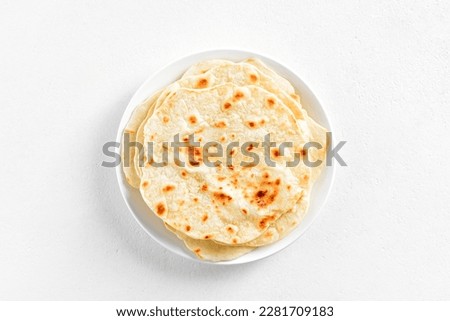 Wheat flat bread on plate over white stone background with copy space. Top view, flat lay Royalty-Free Stock Photo #2281709183