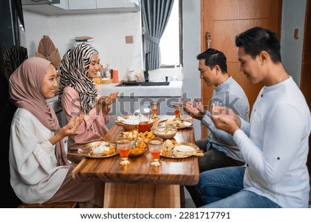 husband and wife pray before meals when breaking the fast together at home Royalty-Free Stock Photo #2281717791