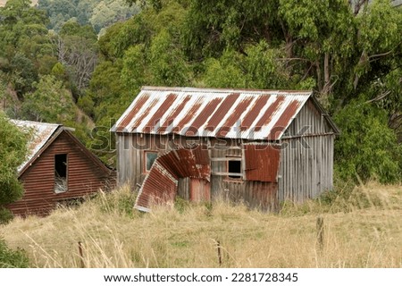 Old rusty derilect sheds in an over grown paddock in rural Tasmania, Australia Royalty-Free Stock Photo #2281728345