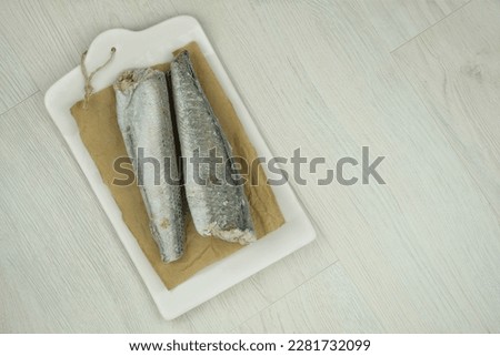 Raw hake on wooden background. Ready to cooking. Iced Hake Filet. Top view. Copy space