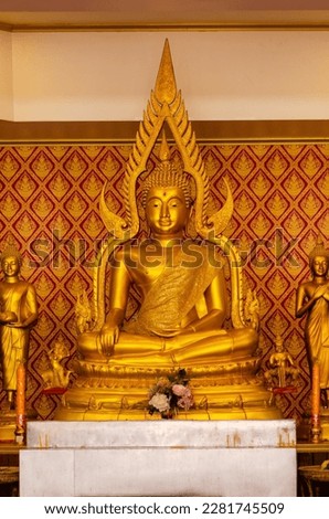 Buddha statue in a Buddhist temple against the background of a wall with a traditional Thai pattern, Buddha Purnima - Buddha's birthday