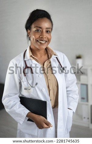 Portrait of a beautiful smiling female African American doctor standing in a medical office. Health care concept, medical insurance, copy space. Royalty-Free Stock Photo #2281745635