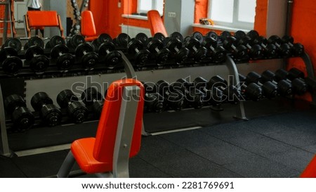 Product photograph of old iron dumbbells on grey, conrete floor in the gym. Photograph taken from above, top view with lots of copy space