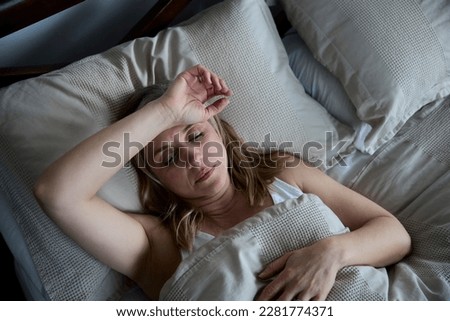 Menopausal Mature Woman Suffering With Insomnia In Bed At Home  Royalty-Free Stock Photo #2281774371