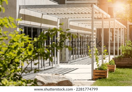 Canopy Awning on Entrance Building. Aluminum Pergola Garden by Modern House with Glass Facade Windows. 