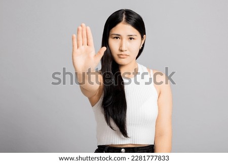 Young adorable asian woman wearing casual white t-shirt doing stop sing with palm of the hand. warning expression with negative and serious gesture on the face.