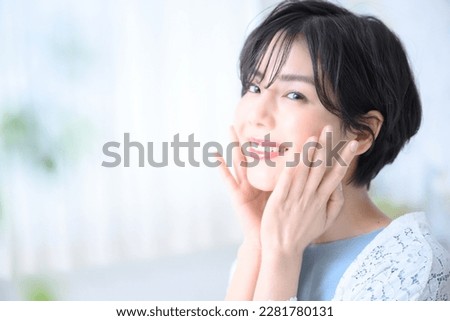 Beautiful Japanese woman with hand on face and smile, easy to use for beauty. Copy space and front blur