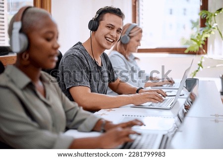 I am humbled to work alongside such a dedication team. Portrait of a young businessman wearing headphones while working on a laptop alongside his colleagues in an office. Royalty-Free Stock Photo #2281799983