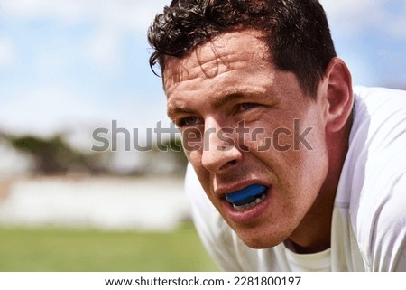 Collision sport requires a bit of extra protection. a young man wearing a gum guard while playing a game of rugby. Royalty-Free Stock Photo #2281800197