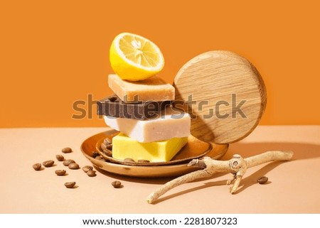 Composition with natural soap bars, lemon, coffee beans and tree branch on color background Royalty-Free Stock Photo #2281807323