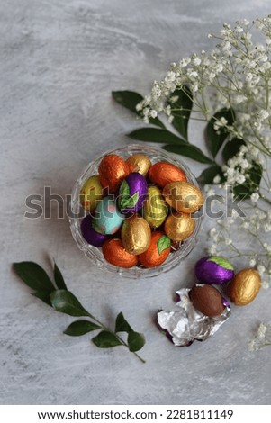 Chocolate eggs wrapped in a foil top view photo. Still life with Easter sweets on a table. 