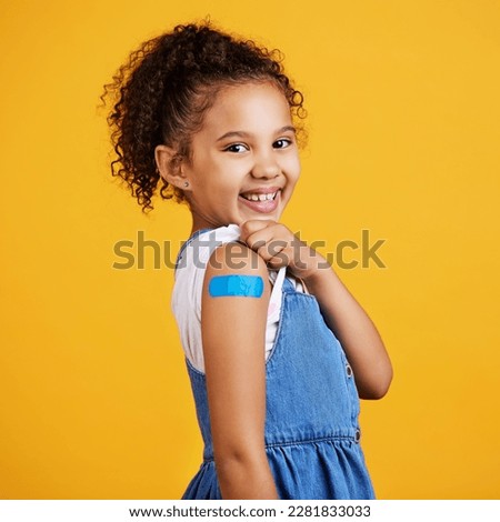 Portrait plaster and girl with smile, confidence and vaccination against a studio background. Face, Latino female child and happy young person showing injection, happiness and cheerful on backdrop Royalty-Free Stock Photo #2281833033
