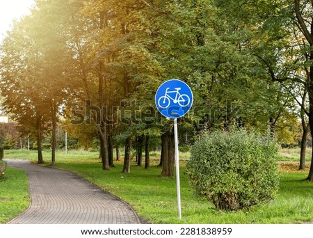 Blue sign with bicycle in park. Special bike lane in the city. Urban background. Close up. Summer, spring activities. Bikes for new lifestyle